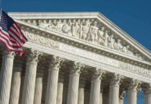 US Supreme Court building facade with flag.