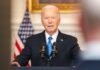 Joe Biden speaking at podium with American flag background