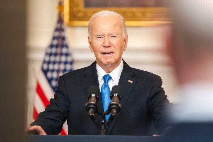 Joe Biden speaking at podium with American flag background