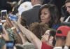 People taking photos with Michelle Obama in a crowd.