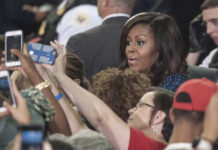 People taking photos with Michelle Obama in a crowd.