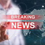 Breaking news graphic over world map background.