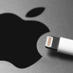 Apple logo next to white Lightning cable.