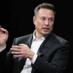 Elon Musk in a suit talking.