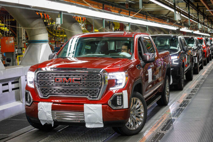 shutterstock_1158206179.jpg featured image General Motors Red GMC pickup truck on assembly line factory