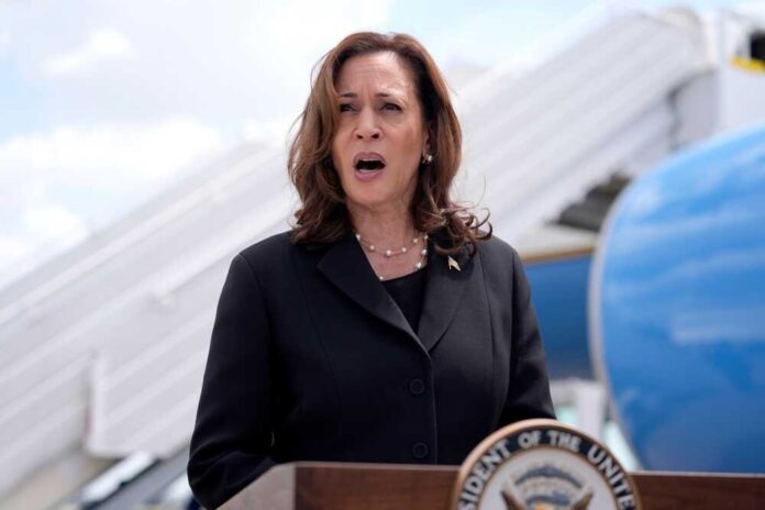 Kamala Harris speaking in front of airplane stairs.