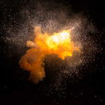 Bright explosion against a dark background with sparks.