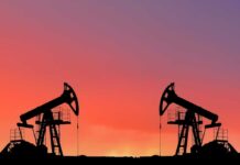 Oil pumps silhouetted against colorful sky background