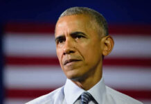 Barack Obama in front of flag.