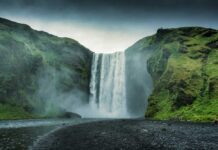 Waterfall cascading between lush green cliffs landscape