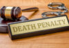 Gavel handcuffs and death penalty sign on table