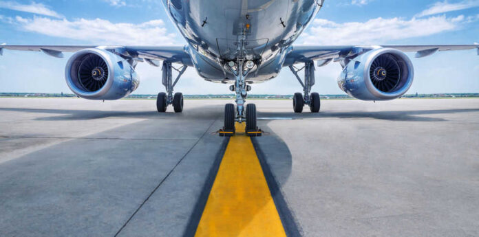 shutterstock_637037008.jpg Airplane on runway with visible landing gear engines