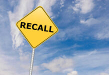 Yellow sign with RECALL text against blue sky
