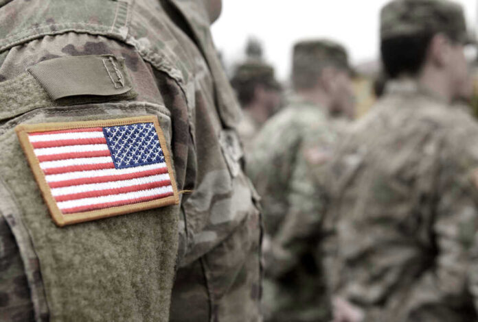 US soldiers in camouflage uniforms with American flag patch
