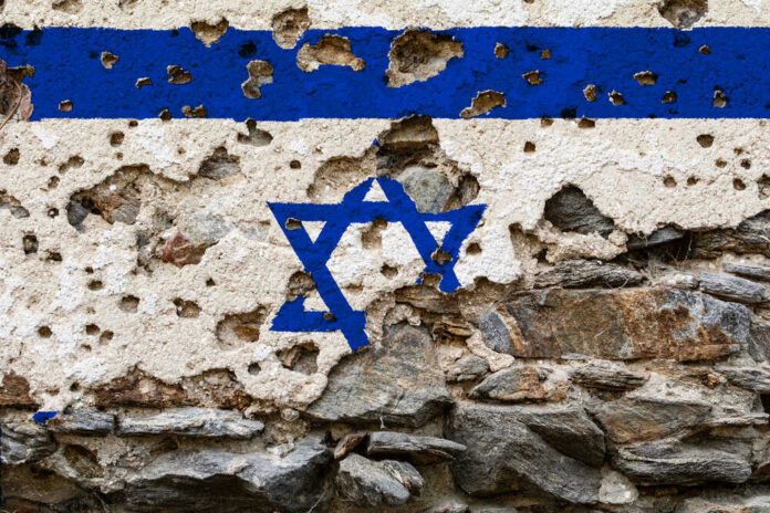 Heavily damaged wall with Israeli flag and Star of David.