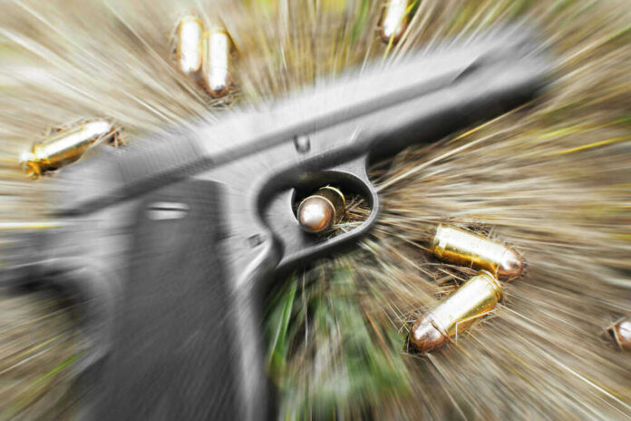 Pistol and bullets on grass with motion blur effect