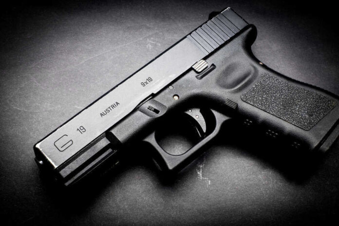 Black Glock 19 pistol on a dark surface