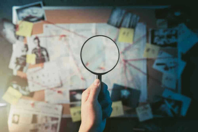 Magnifying glass over investigation board with photos and strings.