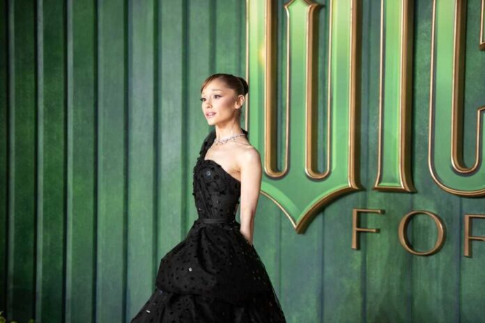Ariana Grande posing in a black gown at a red carpet event