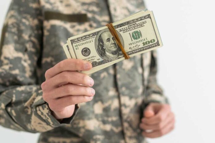 Military personnel holding a bundle of cash