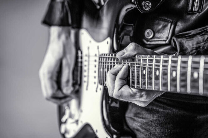 Close-up of a musician's hands playing an electric guitar