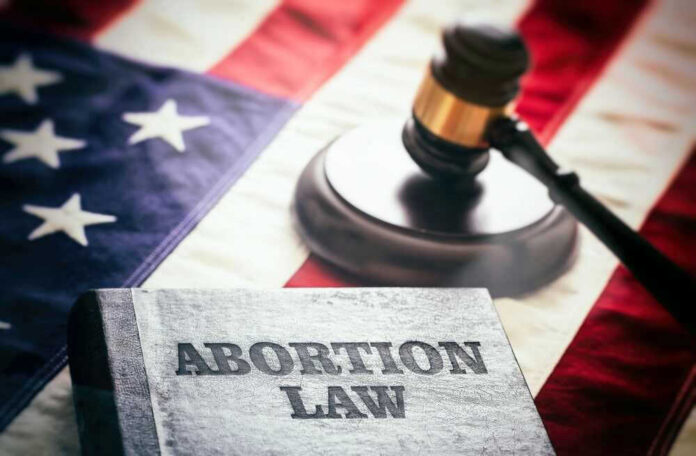 Book titled Abortion Law with gavel and American flag.