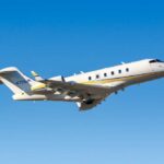 A private jet taking off against a clear blue sky