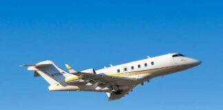 A private jet taking off against a clear blue sky