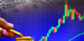 Hand placing gold bars next to a financial graph and dollar bills