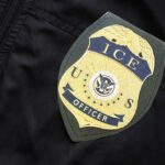 Close-up of an ICE officer badge on a black jacket
