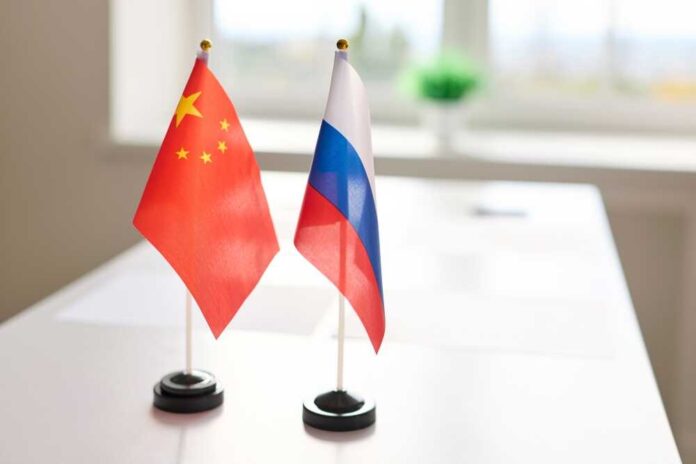shutterstock_2715679027.jpg Chinese and Russian flags displayed on a table