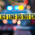 Police tape and lights at crime scene.