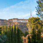 Hollywood sign on hills, surrounded by trees.