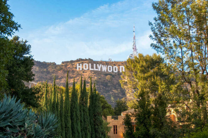 Hollywood sign on hills, surrounded by trees.