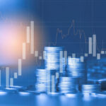 Stacks of coins with financial stock chart overlay.