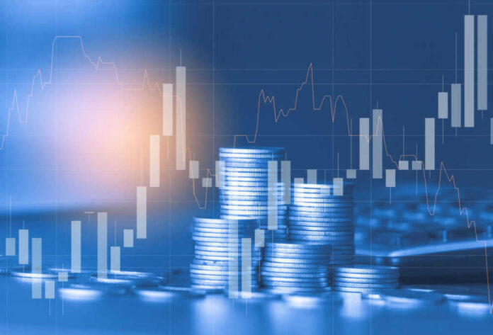 Stacks of coins with financial stock chart overlay.