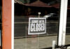 Closed sign hanging on a glass door