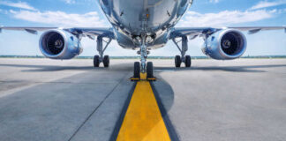 Airplane on runway with visible landing gear engines