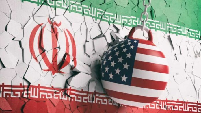 A wrecking ball painted with the American flag is breaking through a wall featuring the Iranian flag