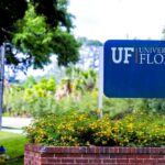 Sign for the University of Florida surrounded by greenery and flowers
