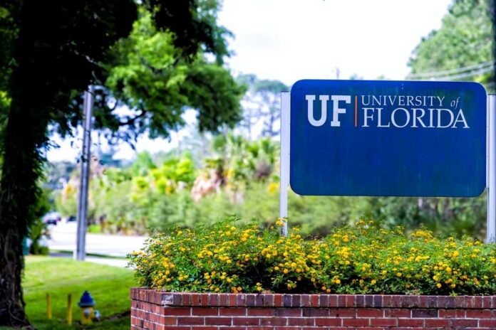 Sign for the University of Florida surrounded by greenery and flowers
