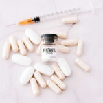 Fentanyl citrate vial surrounded by various pills and syringe.