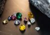 A variety of colorful gemstones scattered on a dark surface