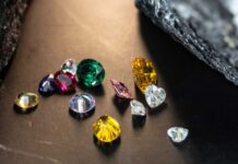 A variety of colorful gemstones scattered on a dark surface