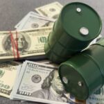 Two green barrels placed on a pile of hundred dollar bills