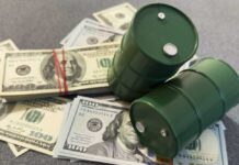 Two green barrels placed on a pile of hundred dollar bills