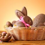A basket filled with various chocolate Easter treats including a bunny and eggs