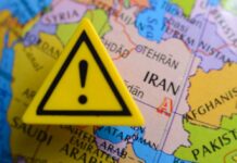 A yellow warning sign placed on a map highlighting Iran