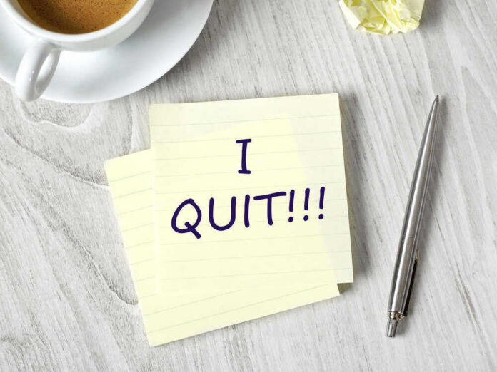 Note with I QUIT near coffee, pen, paper ball.