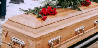 Wooden casket with red roses on top